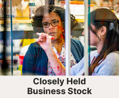 A professor helping a student. Links to Gifts by Closely Held Business Stock