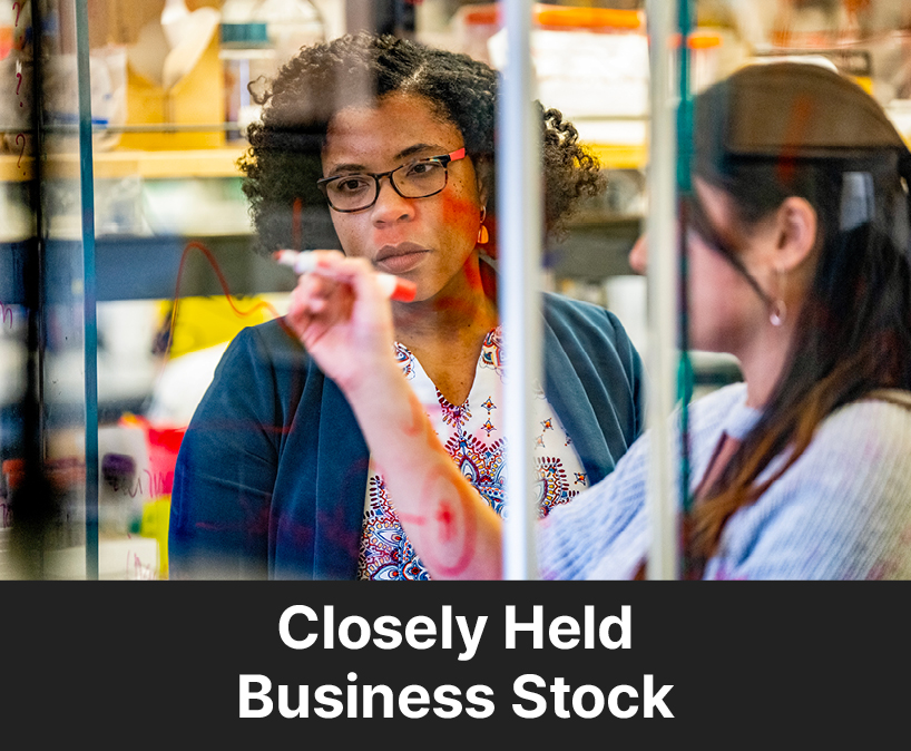 A professor helping a student. Links to Gifts by Closely Held Business Stock